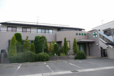 介護施設の建物外観。モダンな平屋造りで、緑の植栽が配置されている。